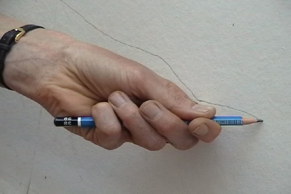 A hand holding a pencil drawing a line