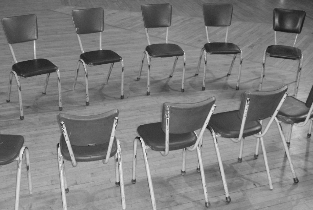 a black and white image of a circle of empty chairs